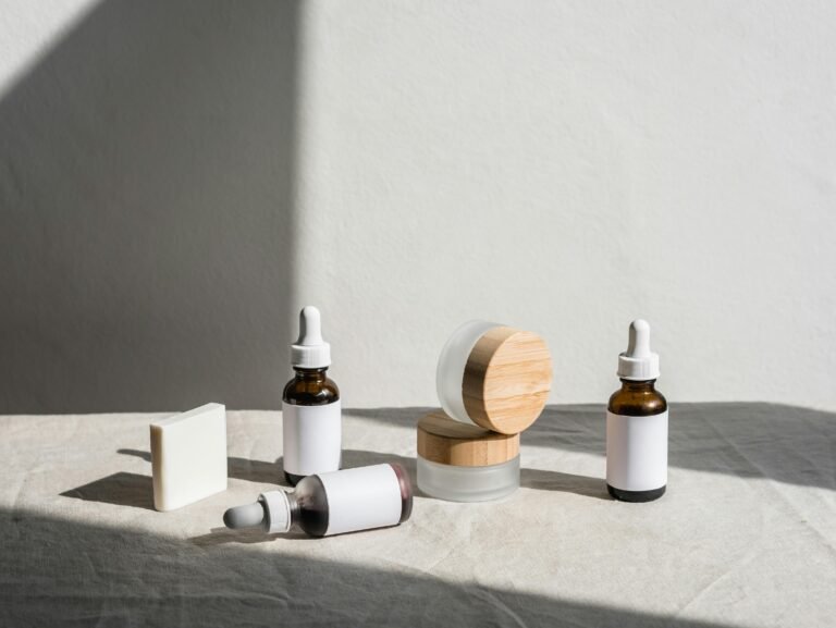 Aesthetic arrangement of skincare products including glass dropper bottles and cream jars with wooden lids, set against a neutral background, ideal for beauty and wellness content.